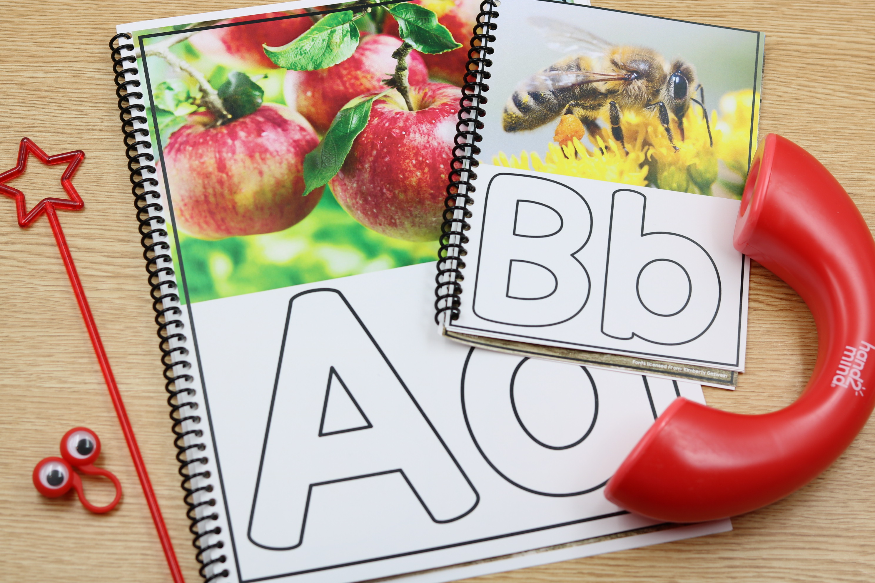 Alphabet phonics center featuring apple and bee photo cards with uppercase and lowercase letters A and B for letter recognition and beginning sound practice.