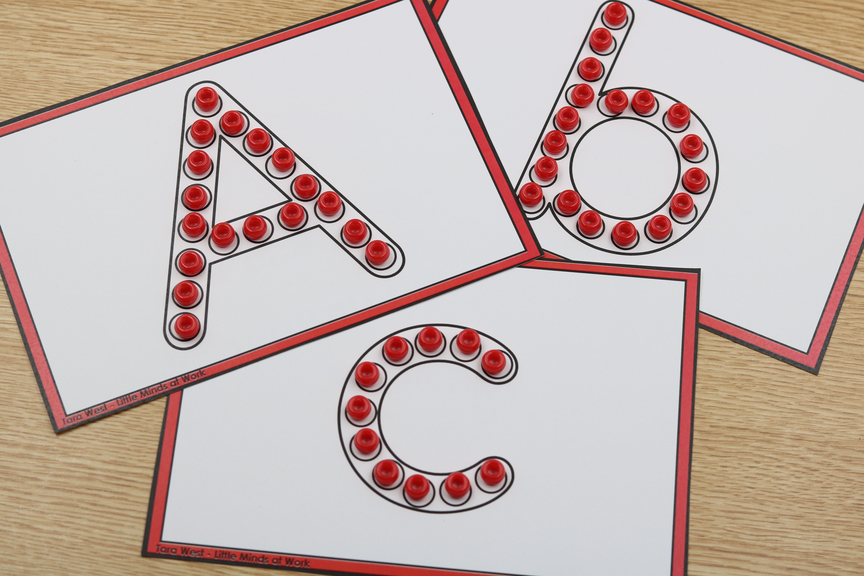 Alphabet fine motor center featuring uppercase and lowercase letter formation cards with manipulatives placed along letter outlines for hands-on alphabet practice.