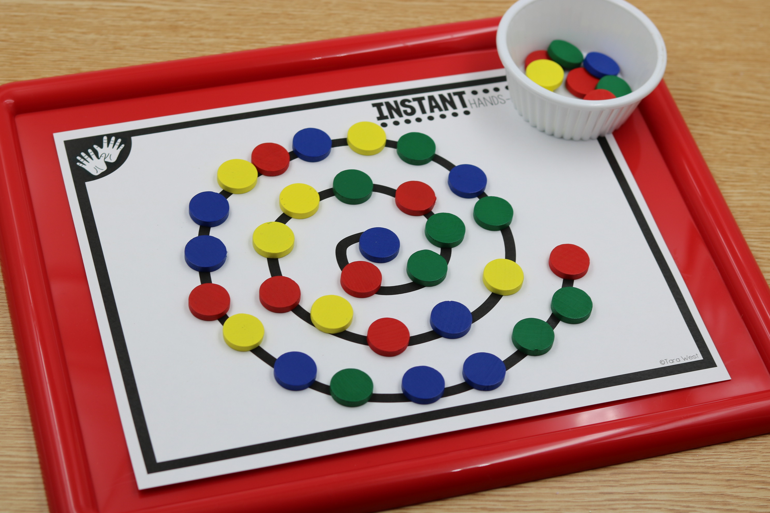 Fine motor center featuring colorful manipulatives placed along a spiral path for hands-on fine motor practice and hand-eye coordination.