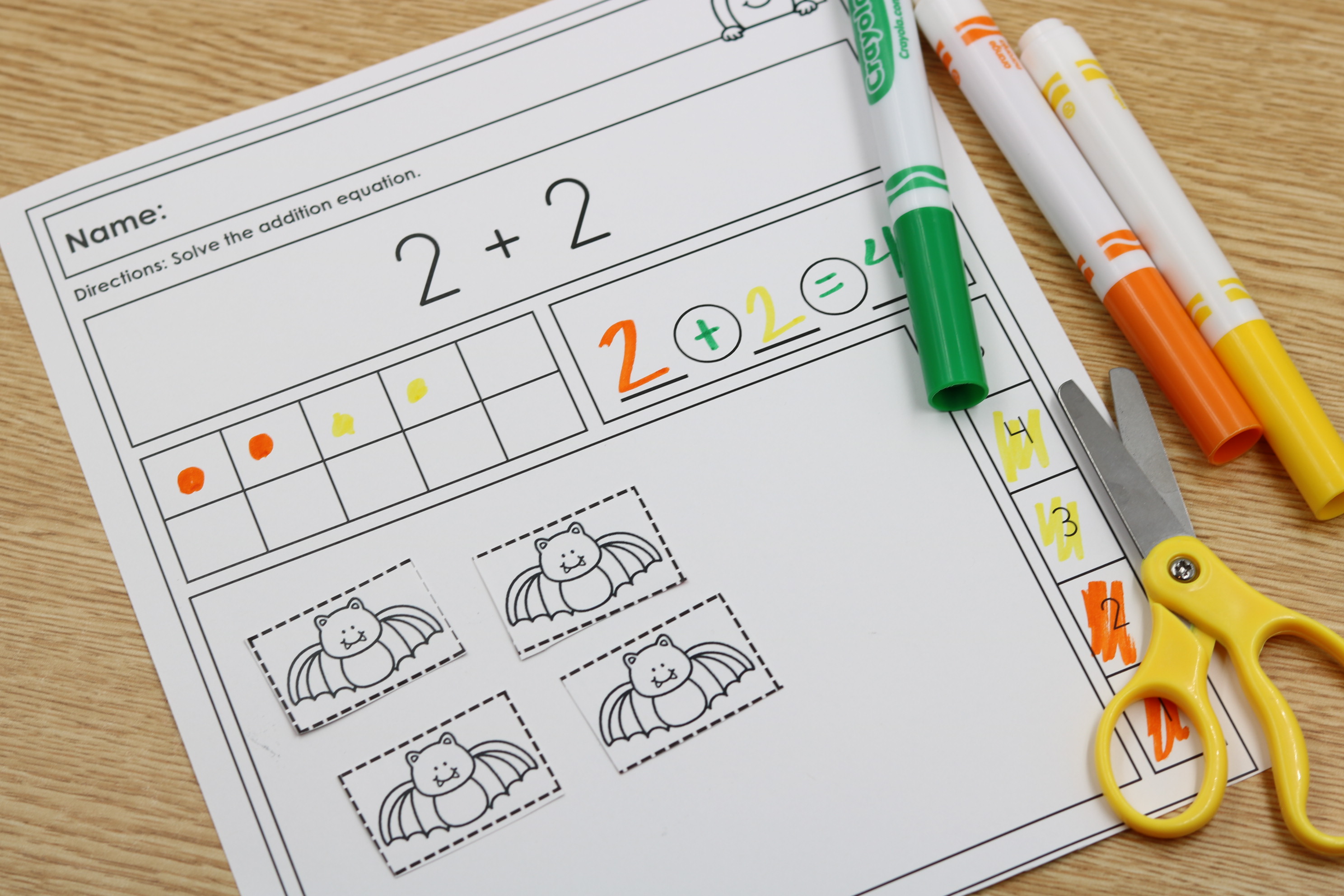 Student solving addition and subtraction equations on October math worksheet