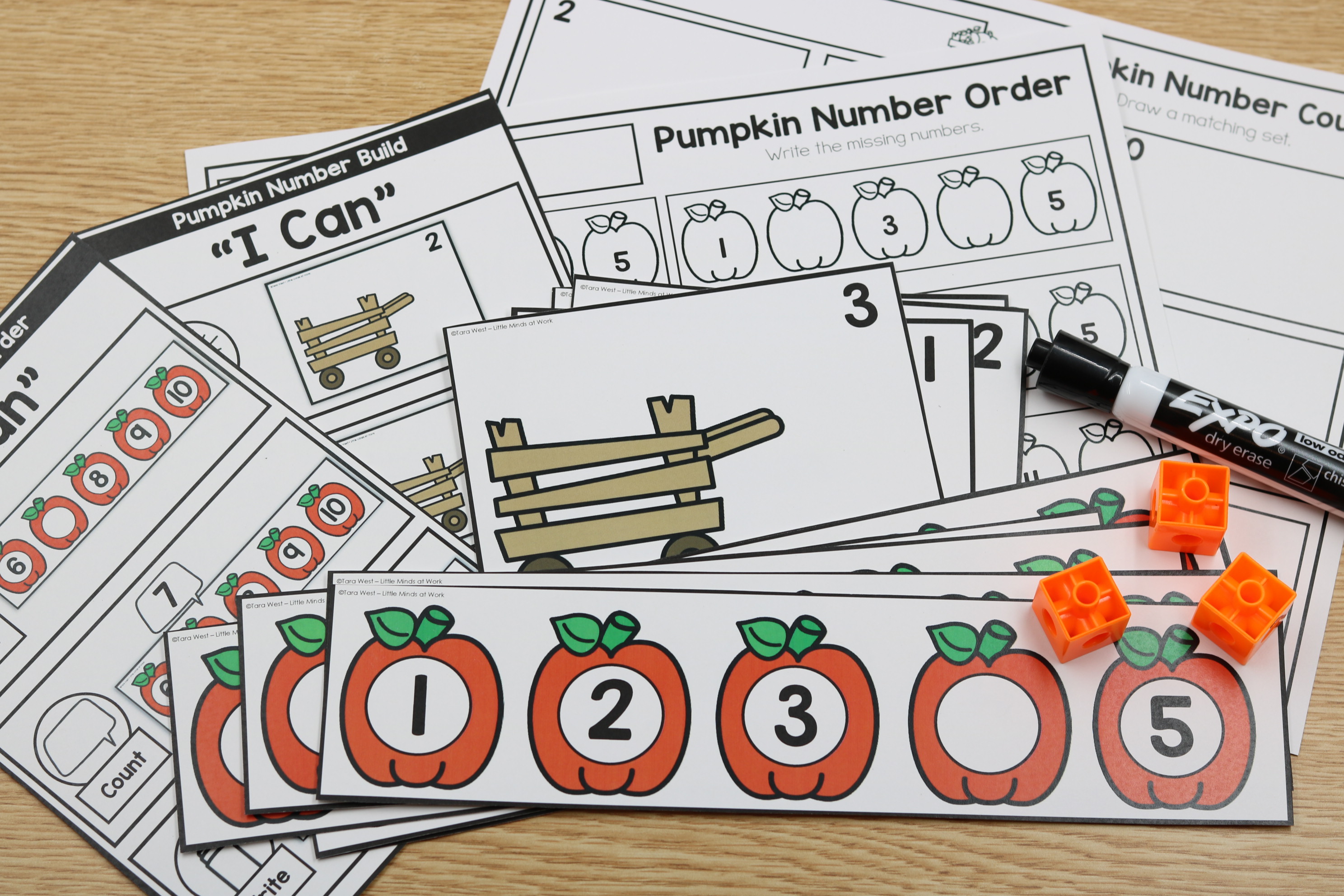 Student writing missing numbers on pumpkin number order worksheet